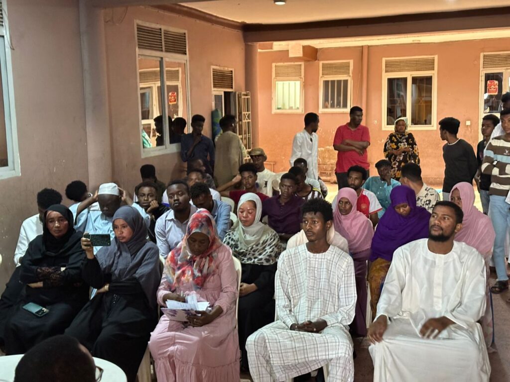 Youth refugees listening to SHRA team during community meeting in Wandegya, Kampala – May 2025